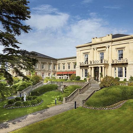 فندق ماكدونالد باث سبا المظهر الخارجي الصورة The photo shows a grand building, likely a hotel or estate, surrounded by well-manicured gardens and lawns. The architecture appears elegant, with multiple stories and large windows. There are steps leading up to the entrance, and the setting include