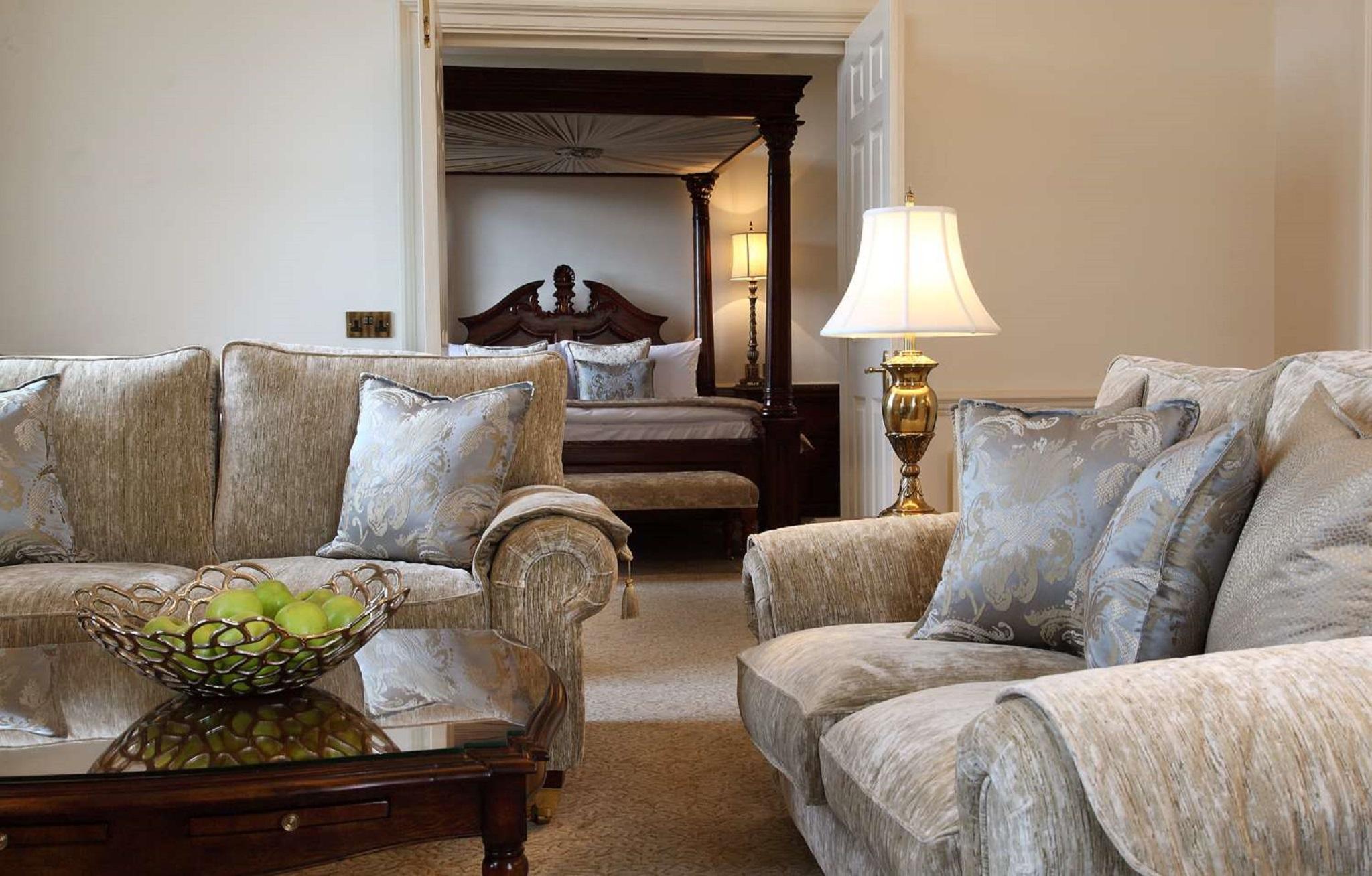 فندق ماكدونالد باث سبا المظهر الخارجي الصورة The photo shows a cozy living space with elegant furnishings. On the left, there is a sofa with plush cushions and a stylish armchair, both in a soft, light-colored fabric. In the center, there is a decorative glass table with a bowl containing what 