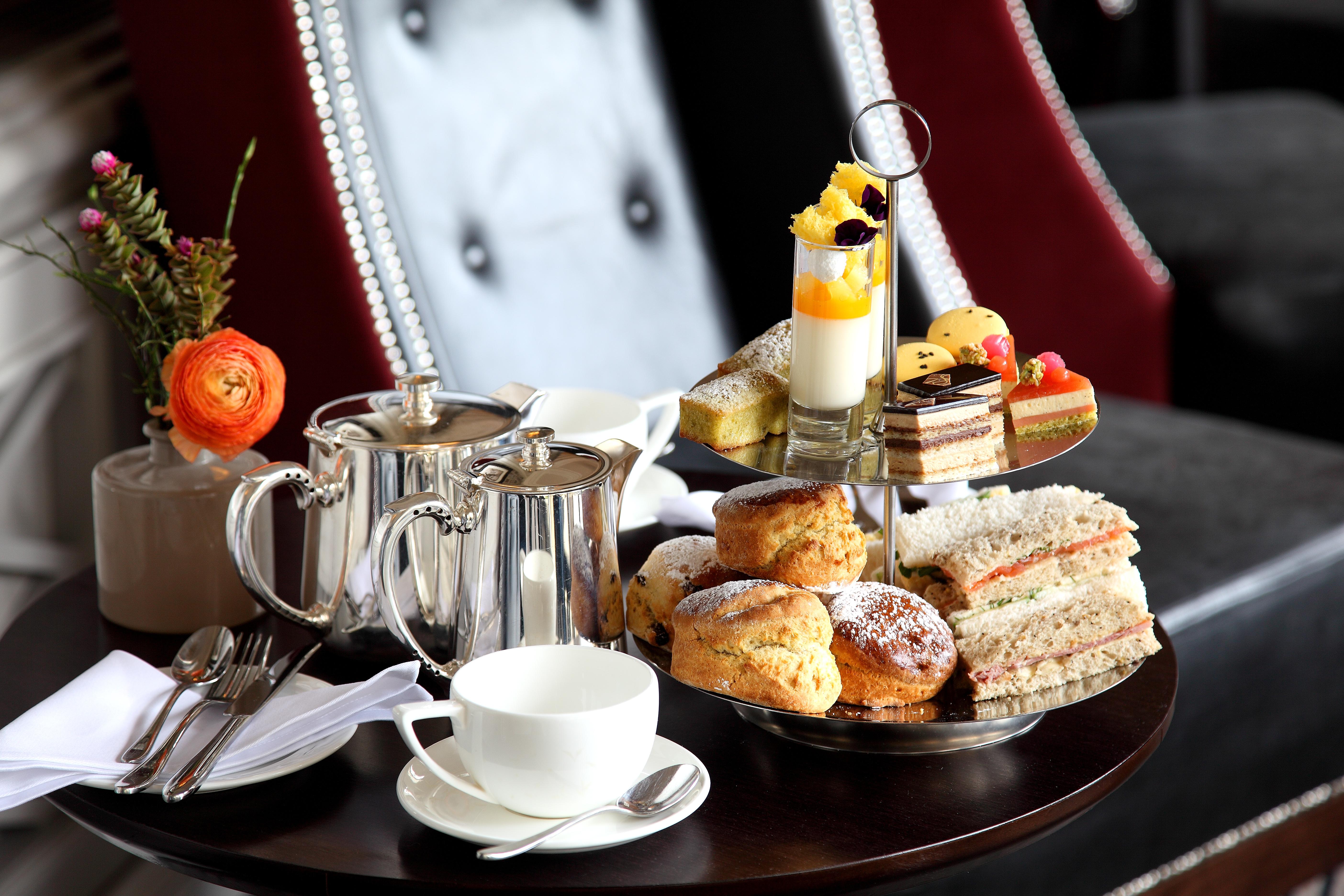 فندق ماكدونالد باث سبا المظهر الخارجي الصورة The photo depicts an elegantly arranged afternoon tea setting. There is a tiered stand filled with a variety of treats, including scones, sandwiches, and small desserts like cakes and pastries. Accompanying this is a teapot and a cup on the table, su